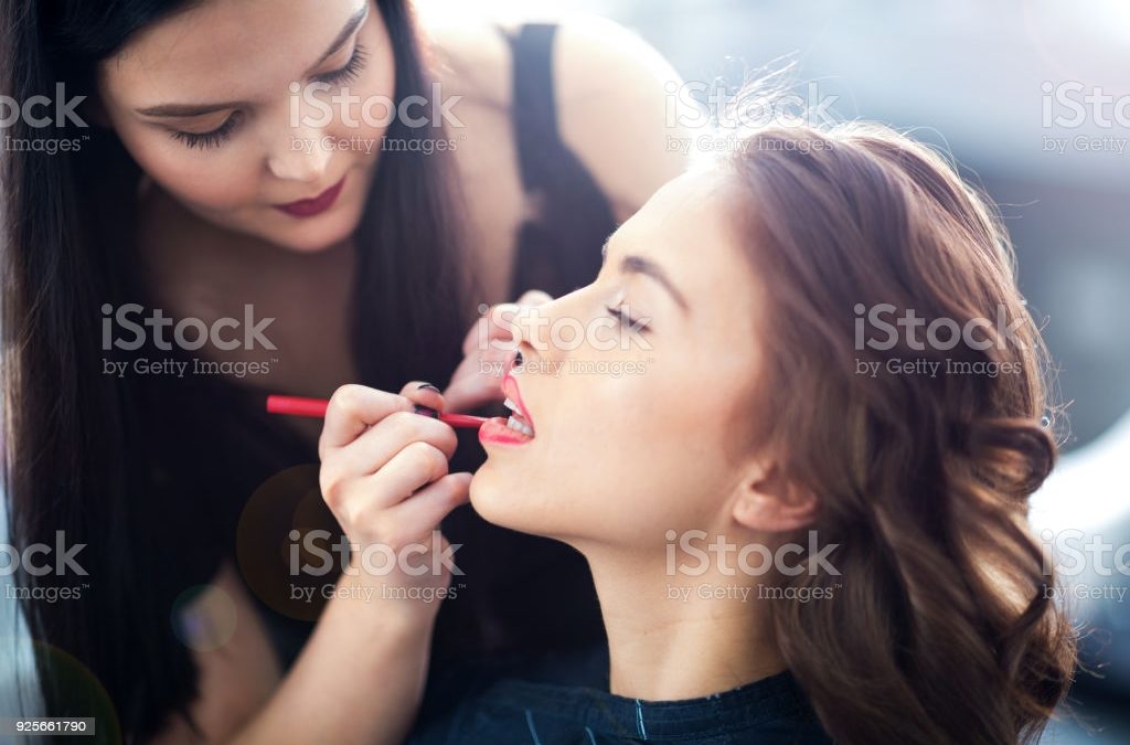 SKISS Female make up artist performing make over in salon